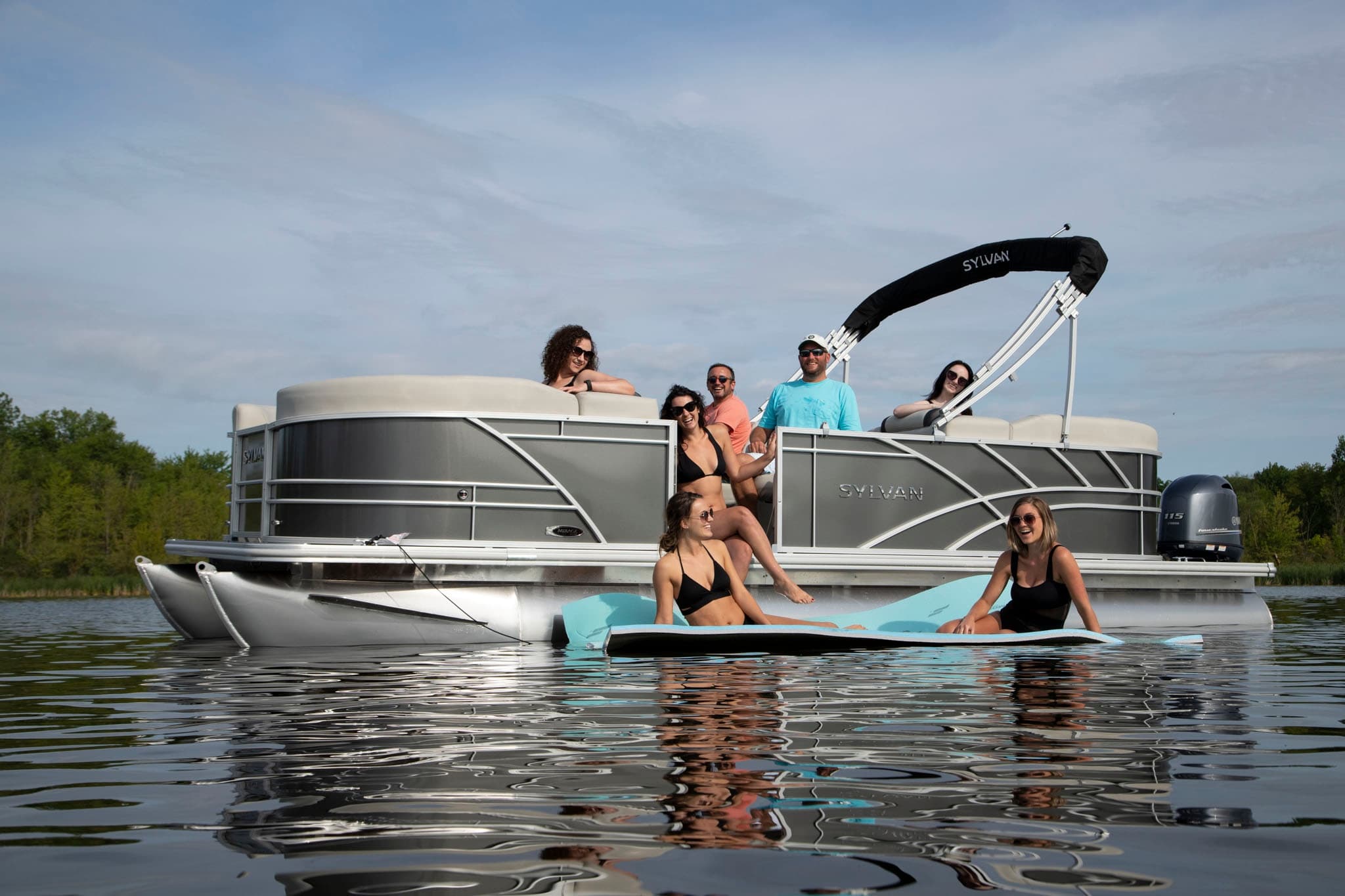 Group enjoying pontoon and paddleboard outing on serene lake