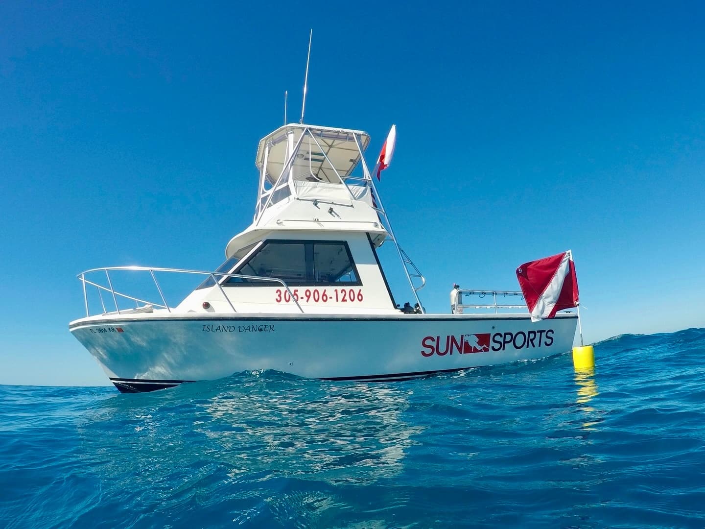 Charter dive boat anchored on clear tropical sea under blue sky