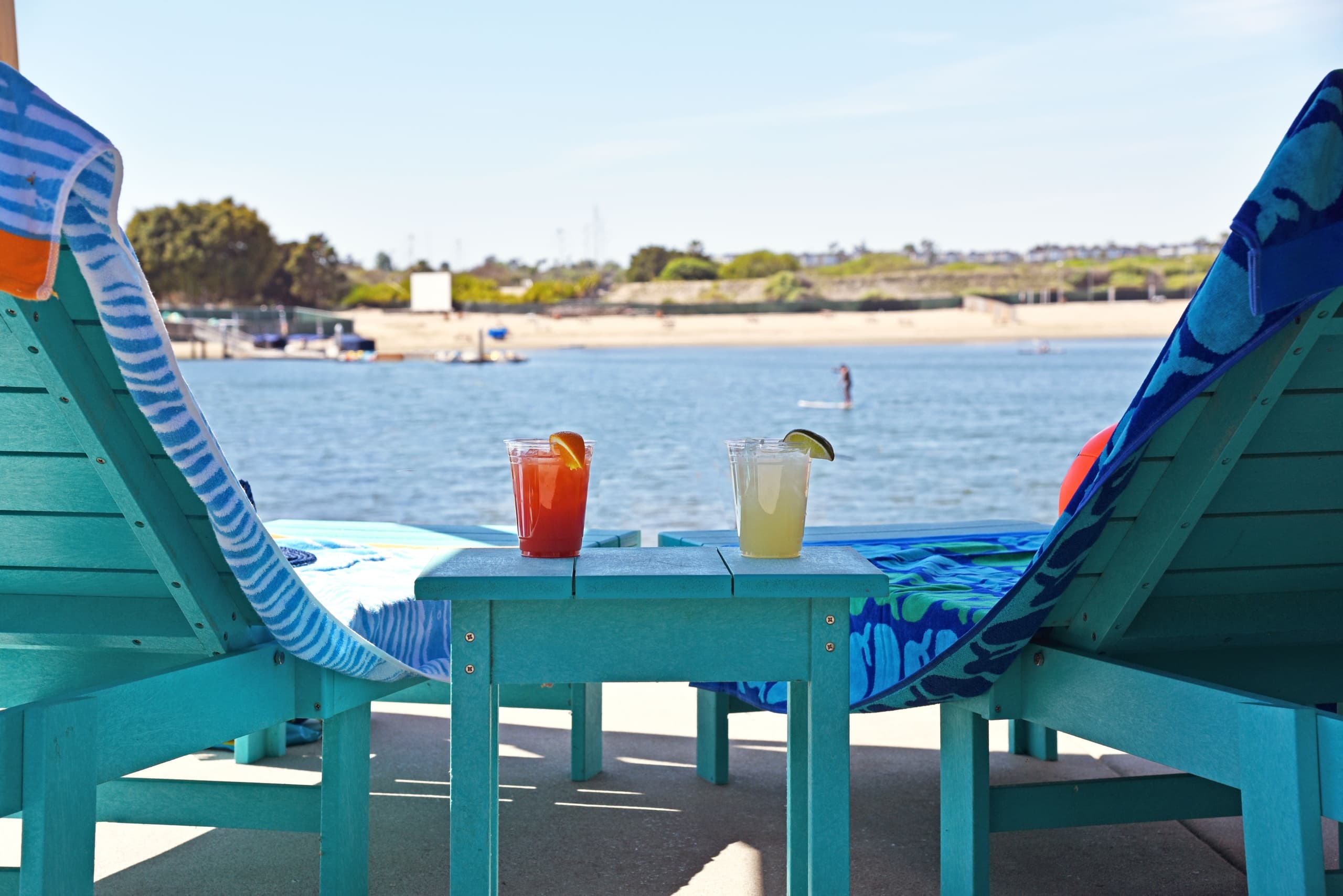 Lounge chairs and cocktails overlooking coastal beach and bay