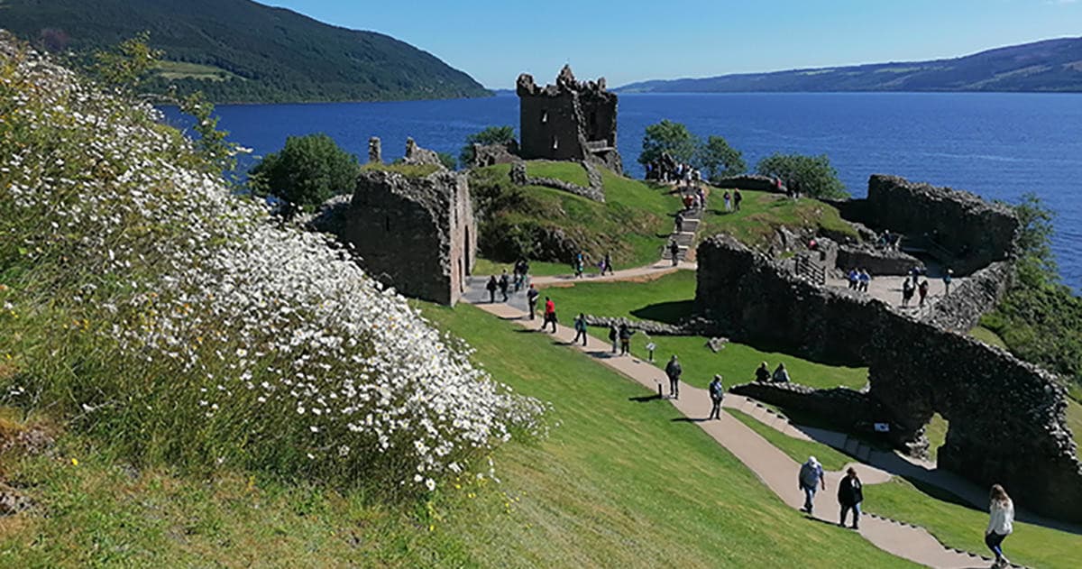 Ruined lakeside castle and grassy banks, historical outdoor exploration