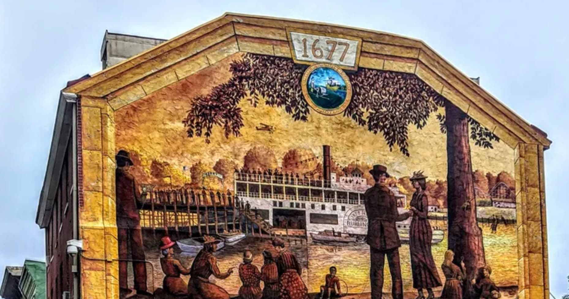 Historic riverfront mural depicting steamboat scene in Burlington