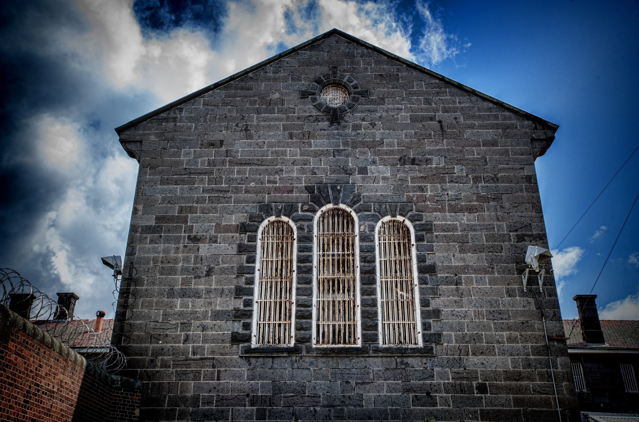Stone gaol chapel facade with barred windows, historic site tour