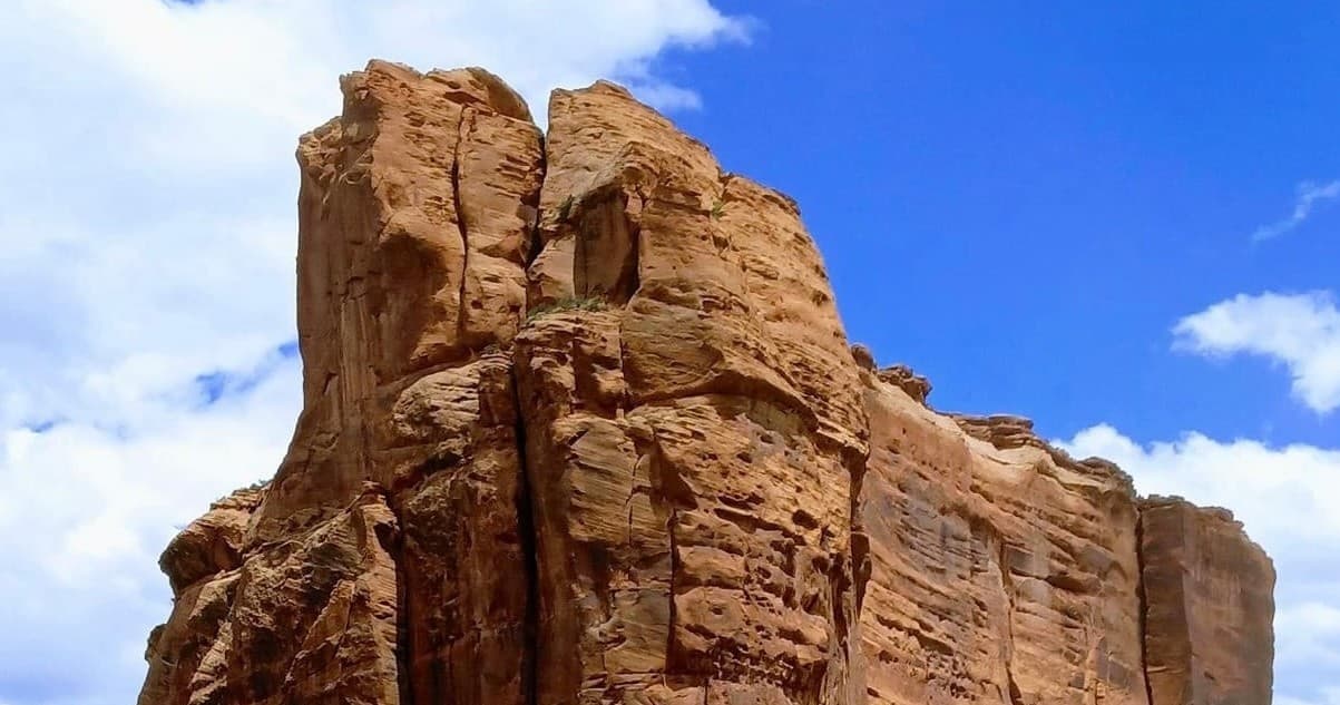 Towering sandstone monolith against vivid blue sky in canyon