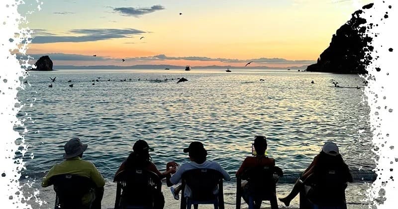 Sunset silhouettes watching ocean horizon in Baja bay