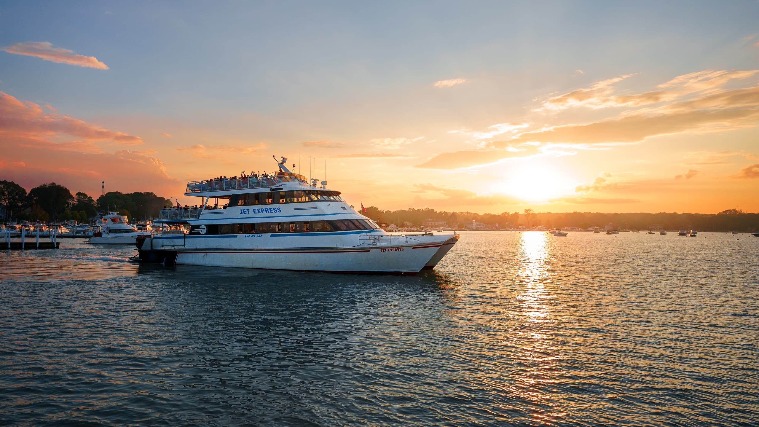 Passenger ferry cruising at sunset over island harbor waters