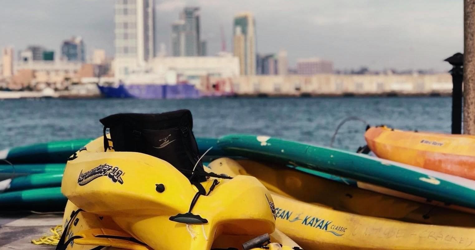 Yellow jet ski parked by waterfront with city skyline