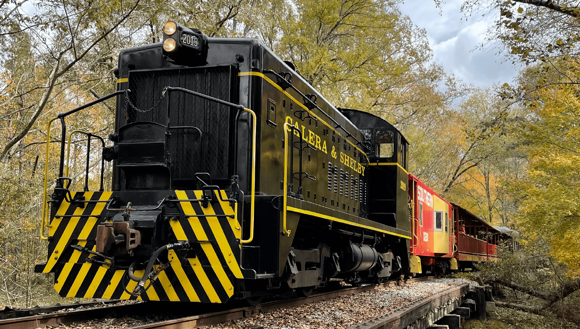 Front view vintage locomotive traveling through autumn forest
