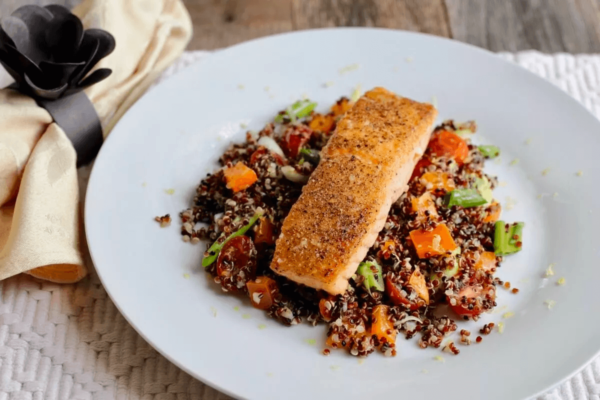 Pan-seared salmon atop quinoa salad, plated gourmet lunch scene
