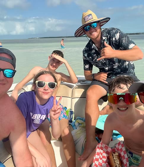 Friends boating at shallow sandbar in clear tropical waters