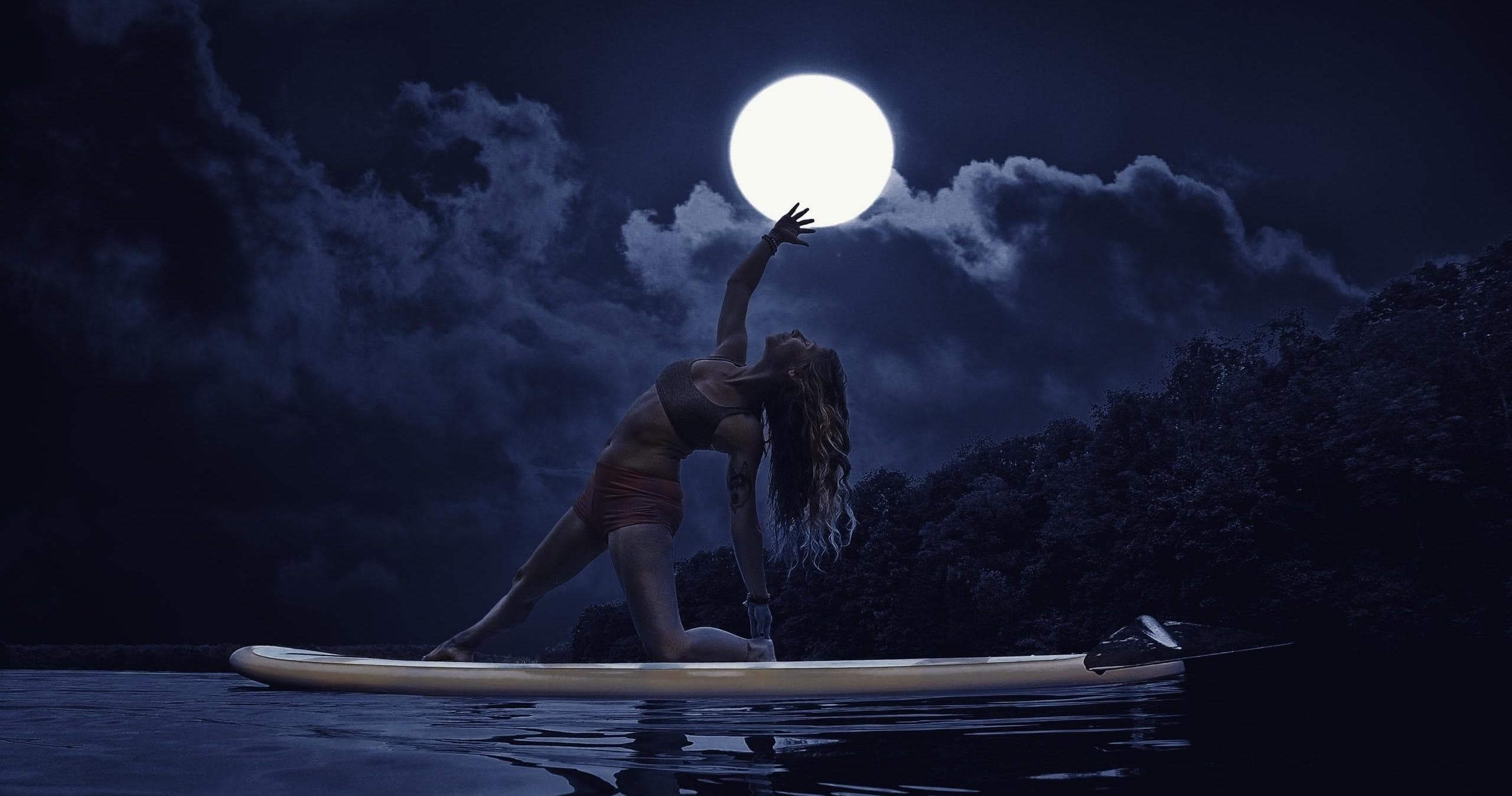 Moonlit paddleboard yoga session on calm reflective river night