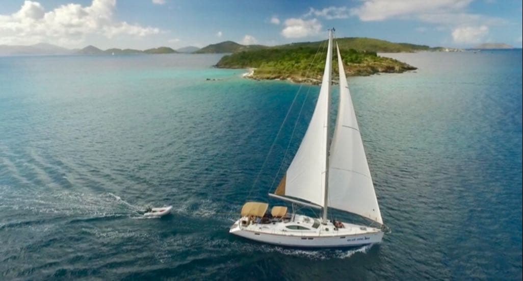 Aerial view of sailing yacht near lush Caribbean island coast