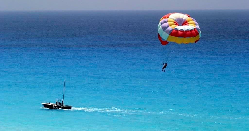 Parasailing over turquoise ocean with tow boat offshore