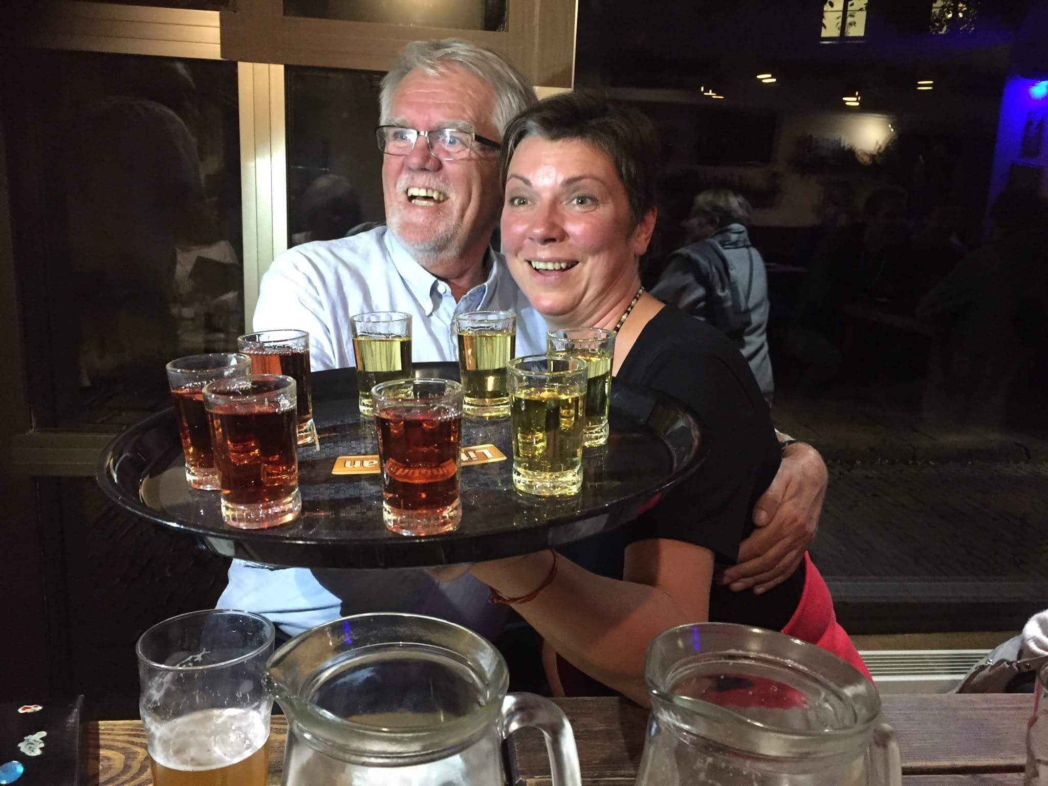 Bartender serving multiple shot glasses at lively Baltic pub
