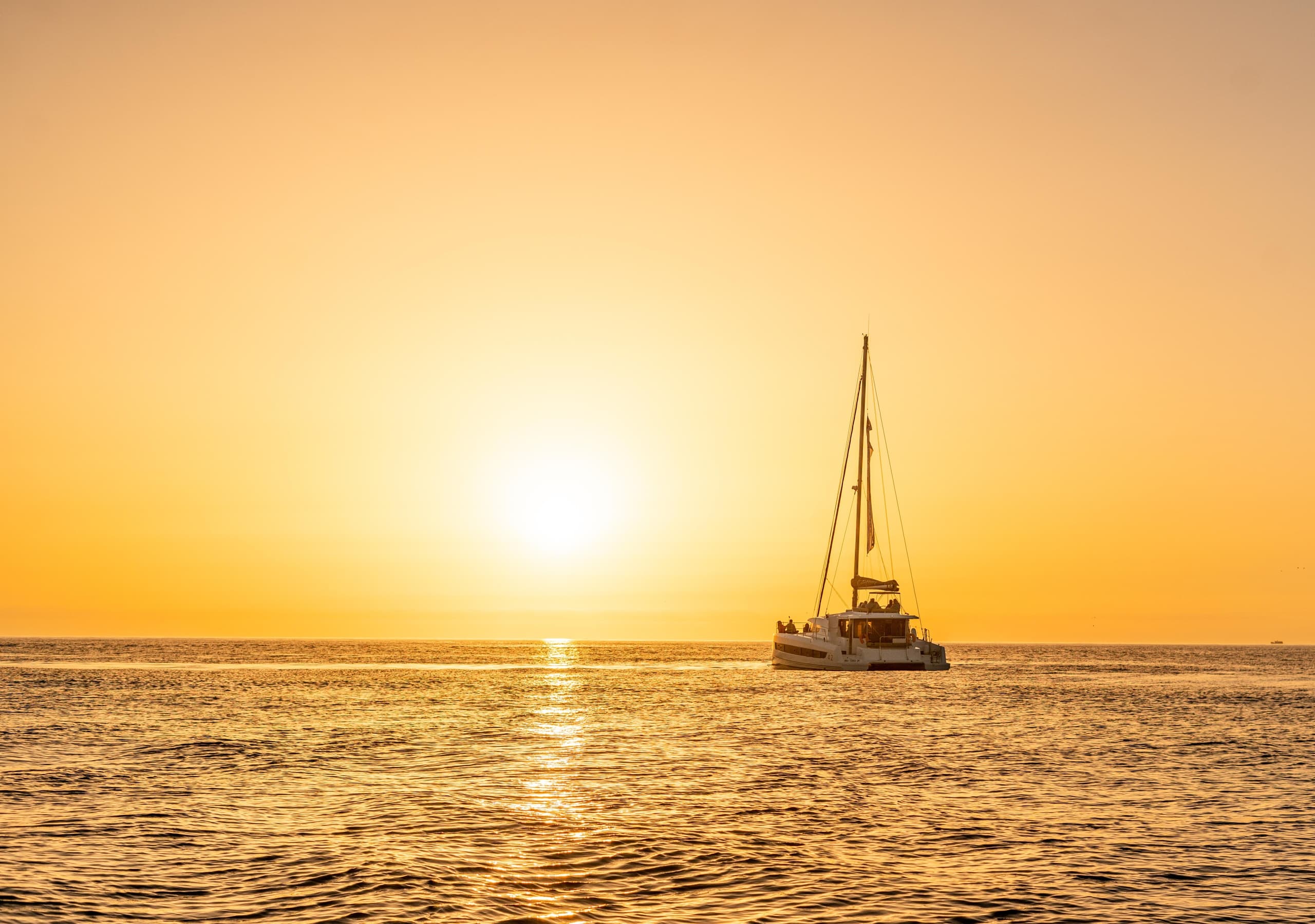 Catamaran silhouette at sunset on open sea near Porto