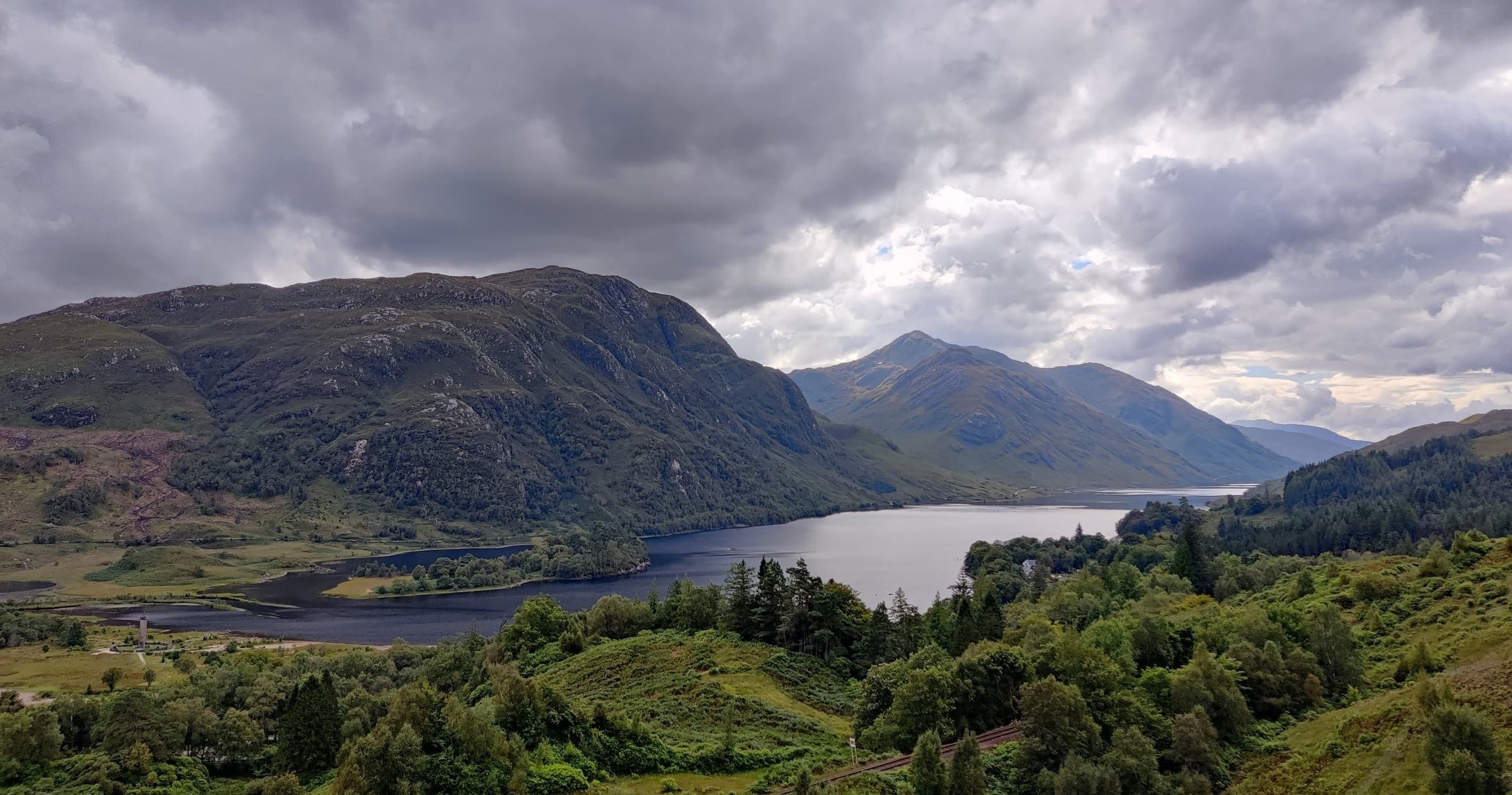 Dramatic highland loch and mountain panorama under stormy skies