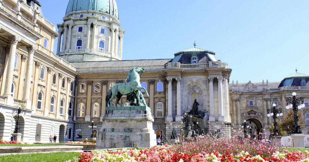Historic palace courtyard with dome and equestrian statue at Buda