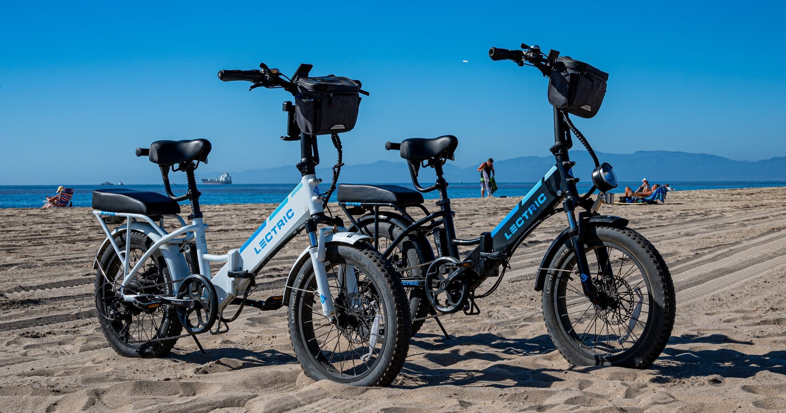 Pair of beach cruisers on sandy shore with ocean horizon