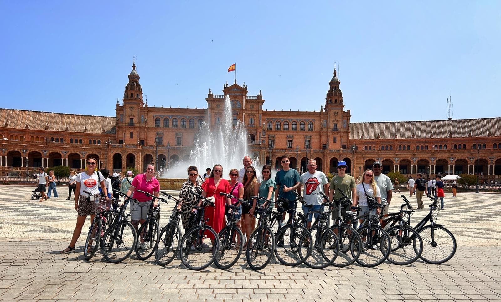 Cyclists posing with bikes at Plaza de España, Seville