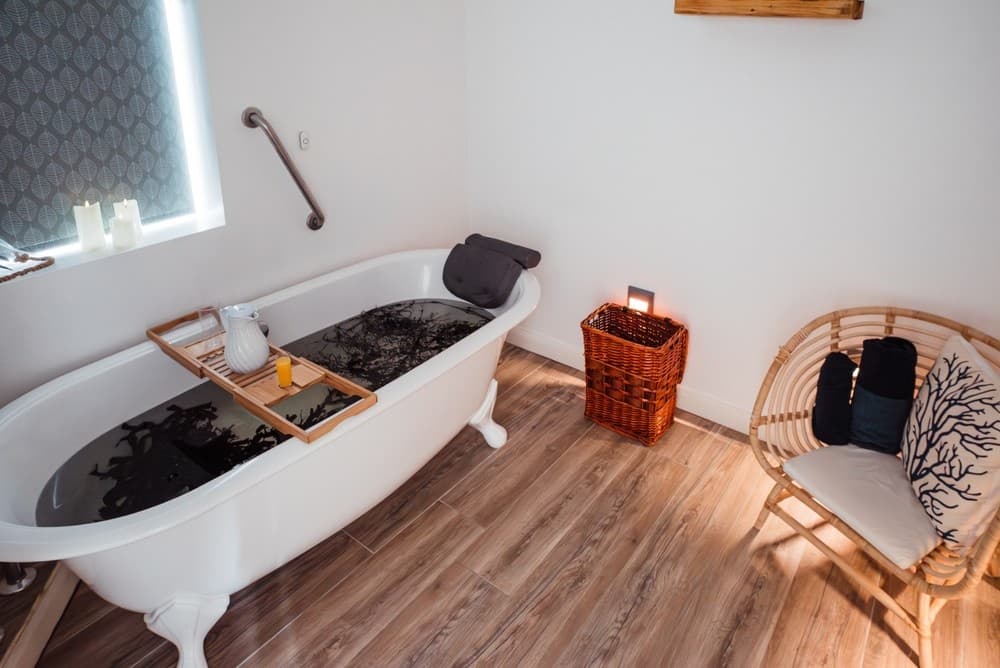 Clawfoot tub seaweed bath in cozy indoor spa room setting