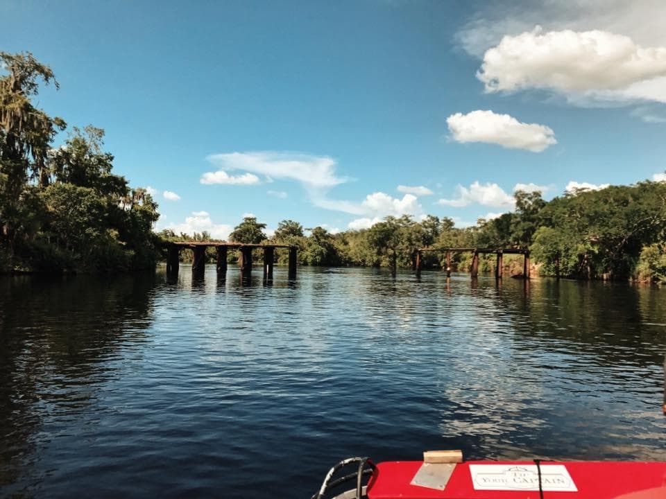 Airboat cruising past river bridge on Florida swamp tour