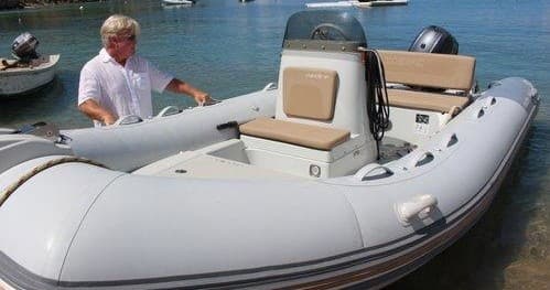 Inflatable dinghy tied at shore showing console and seating
