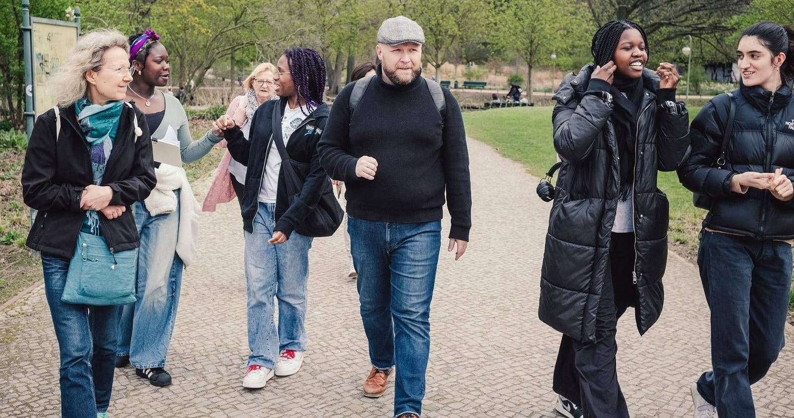 Guided walking tour group exploring urban park paths in spring
