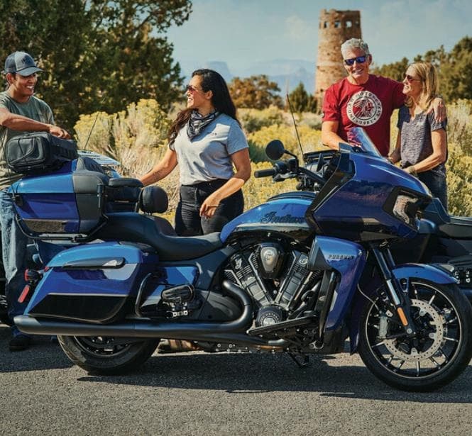 Group of riders by blue touring bikes at desert overlook