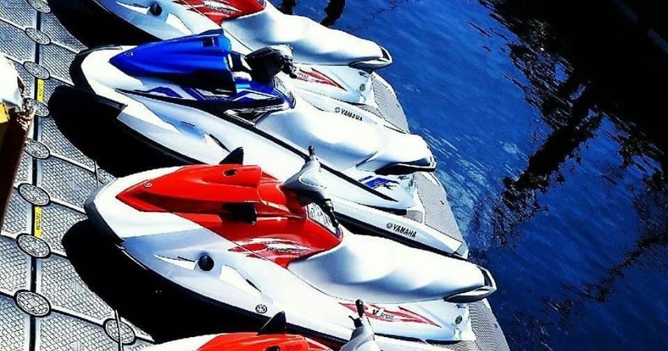 Line of jet skis docked at marina on calm tropical harbor