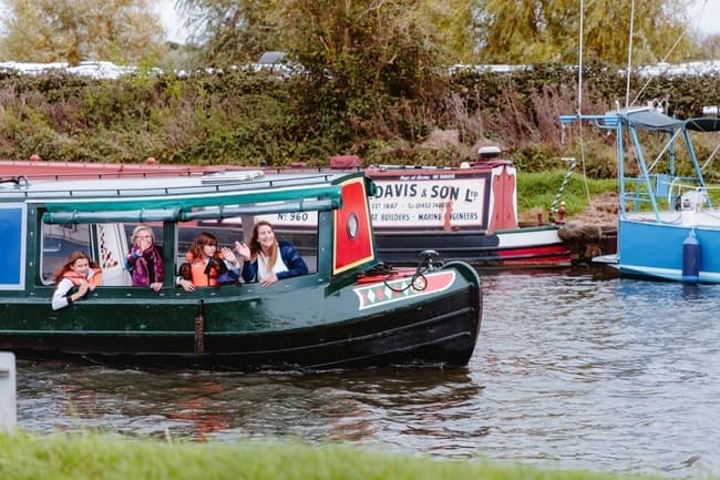 Family on narrowboat enjoying canal cruise near Tattenhall Marina