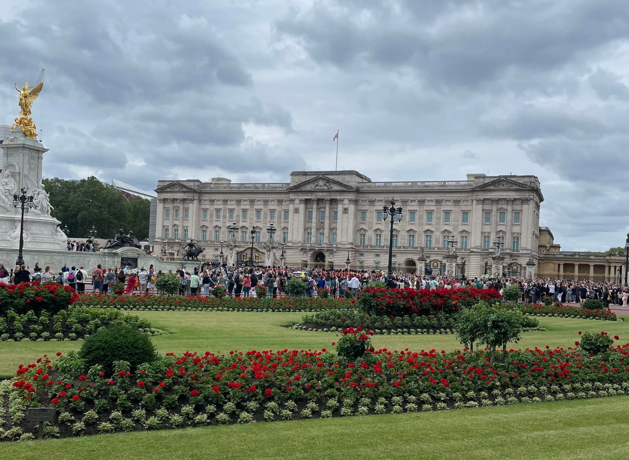 Crowds and flowerbeds outside Buckingham Palace in London ceremonial gardens