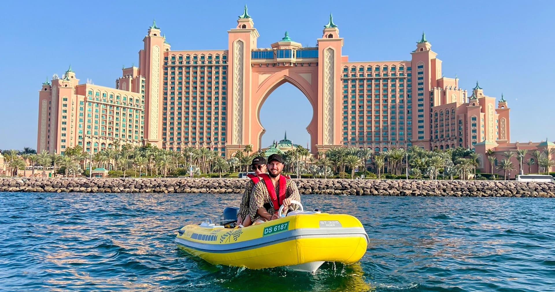 Driver on yellow RIB boat cruising in front of Atlantis, Dubai