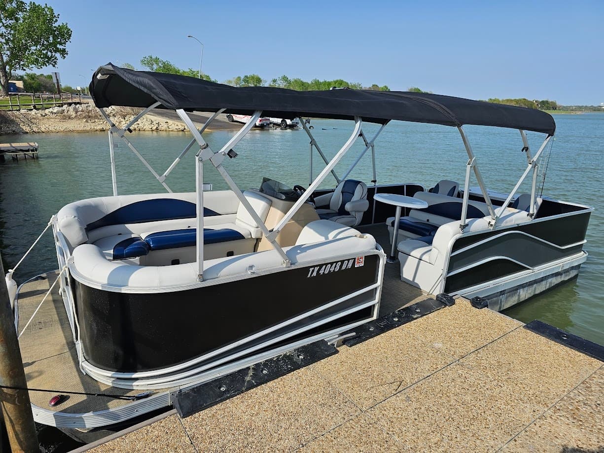 Pontoon boat rental docked on a sunny lake ready for cruising