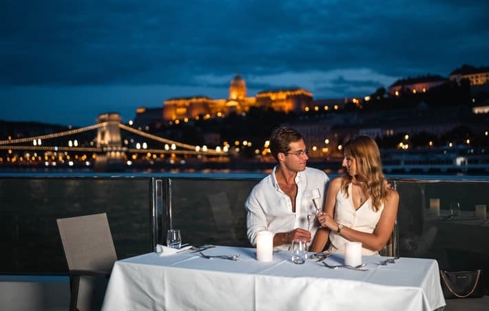Couple dining on Danube terrace with Chain Bridge and Buda Castle