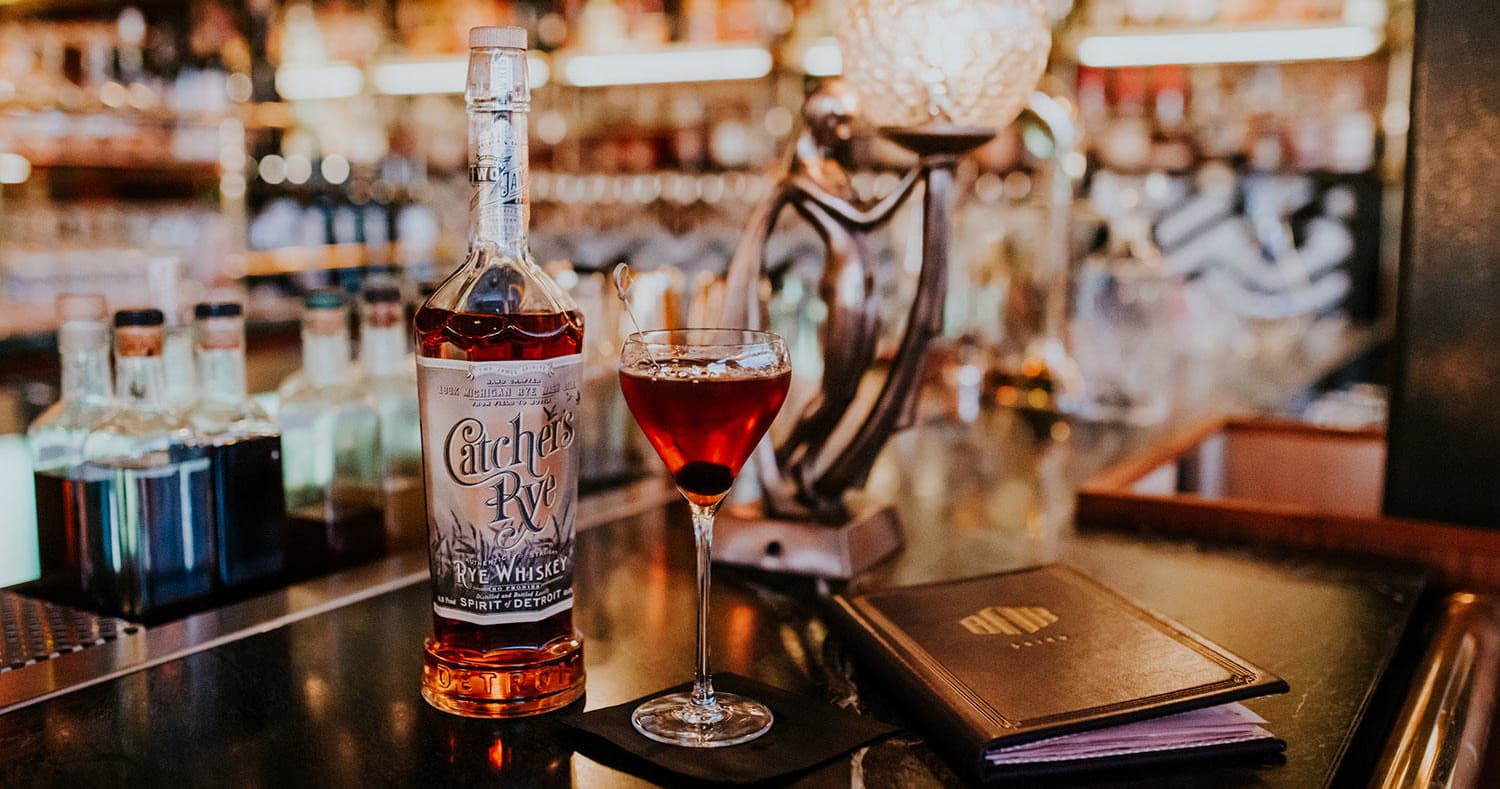 Whiskey cocktail and Two James bottle in distillery tasting-room bar