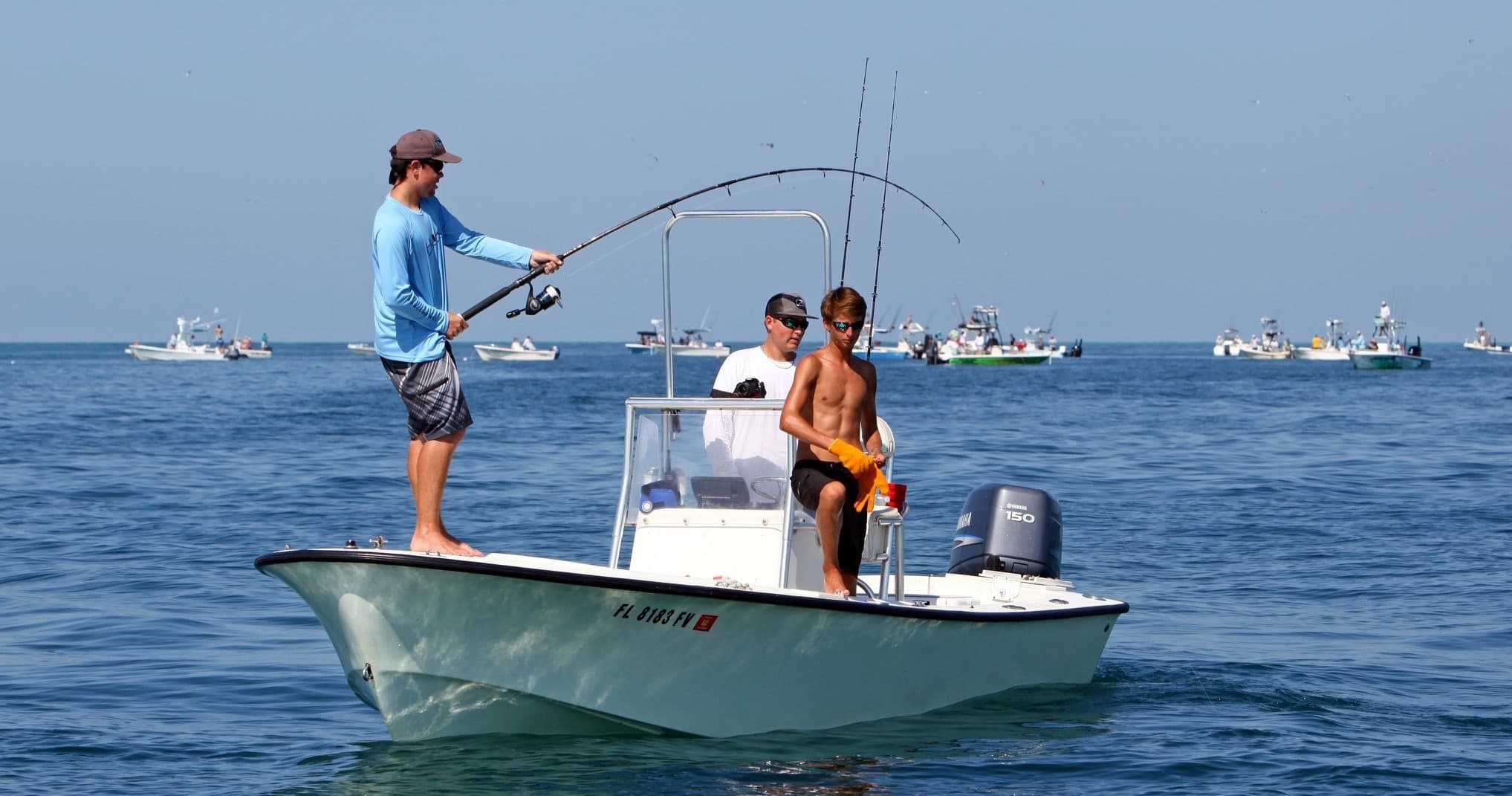 Anglers on a flats boat fishing in calm blue ocean