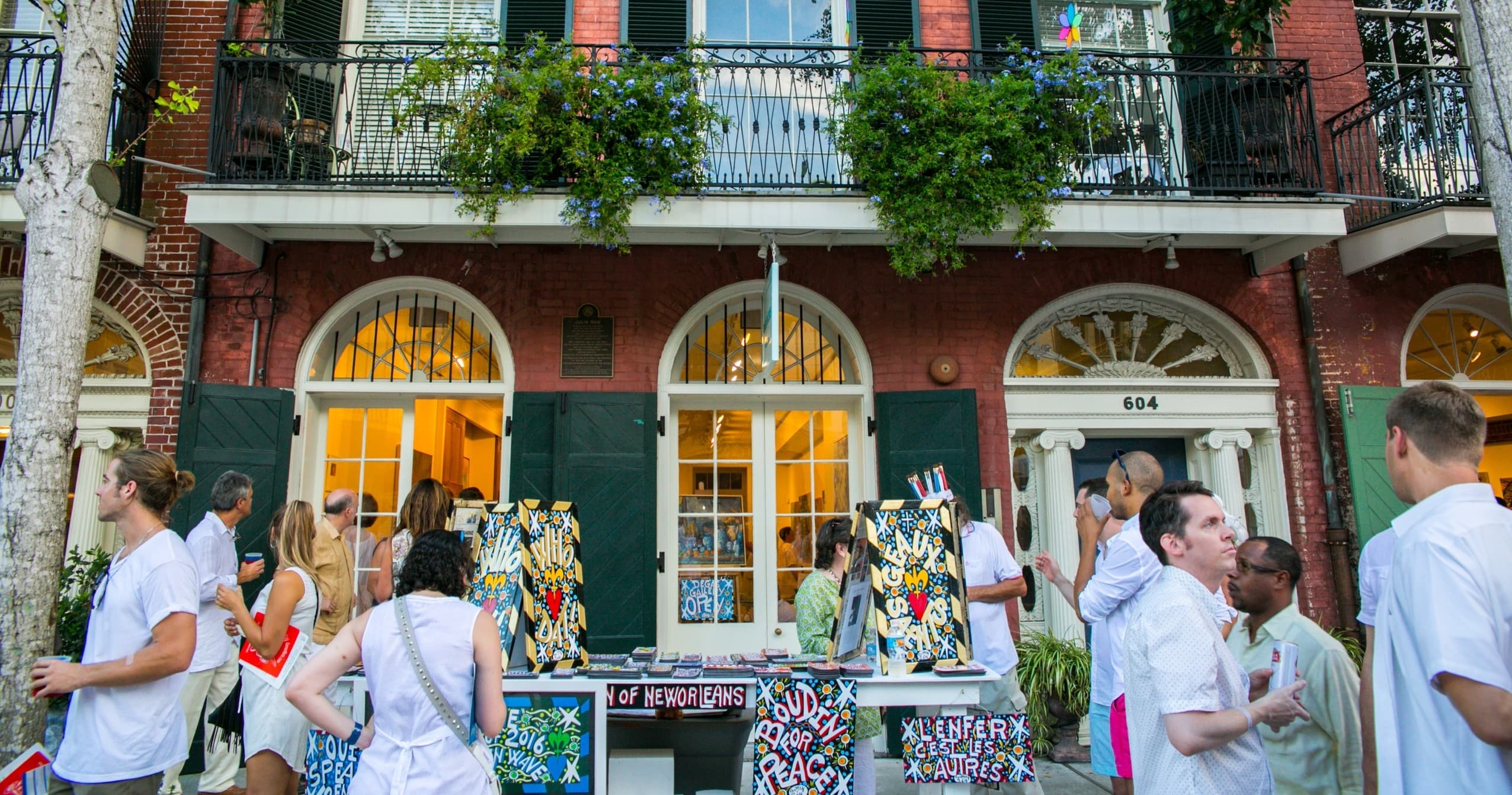 Outdoor art market on French Quarter balcony-lined street in New Orleans