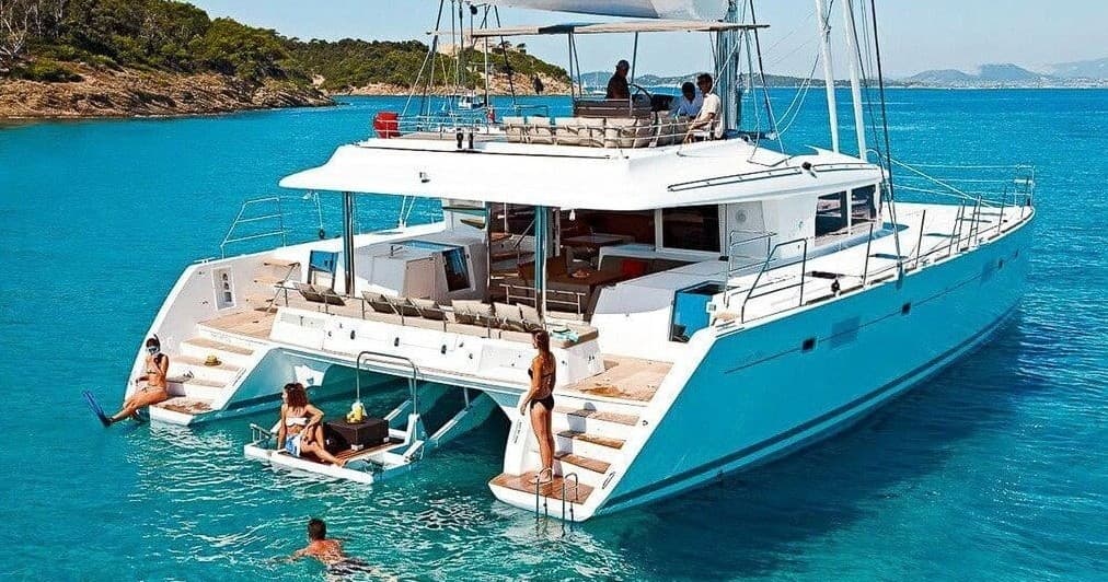 Catamaran yacht anchored in turquoise tropical sea, leisure cruise