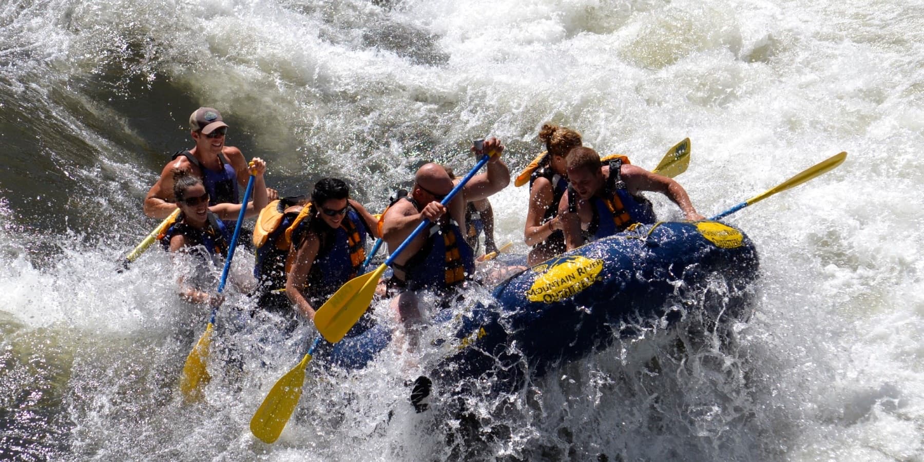 Whitewater rafters navigating powerful rapids in canyon river