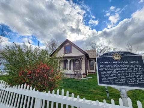 Willa Cather childhood home exterior with historical marker and fence