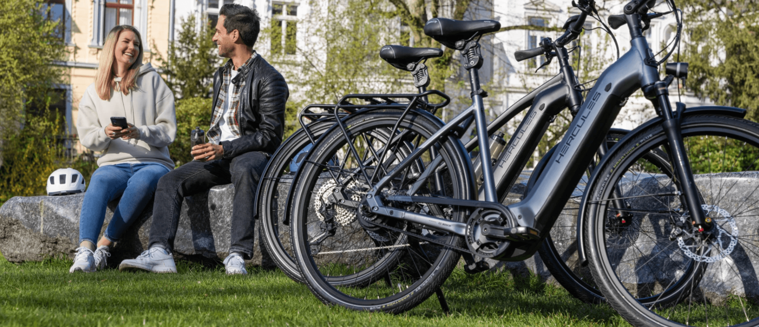 Couple relaxing with rental bikes in urban park for bike tour