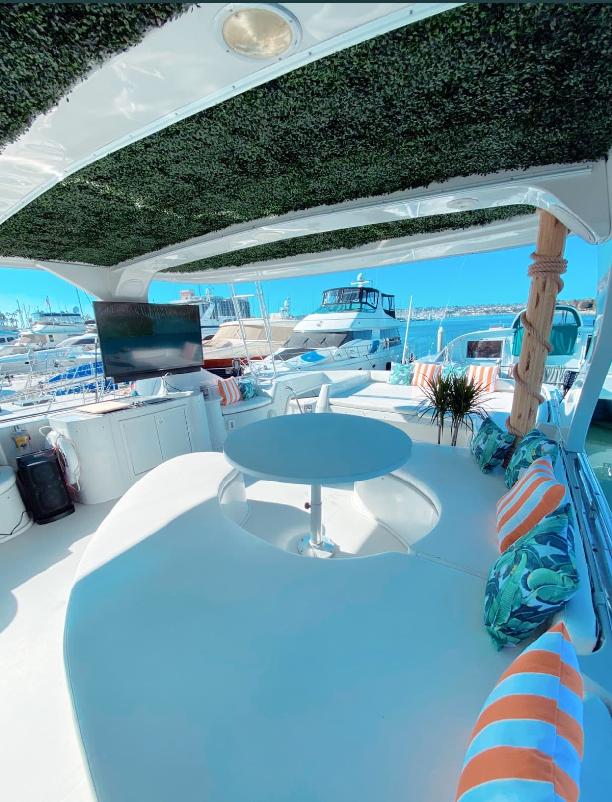 Upper deck seating area on yacht with views of nearby boats