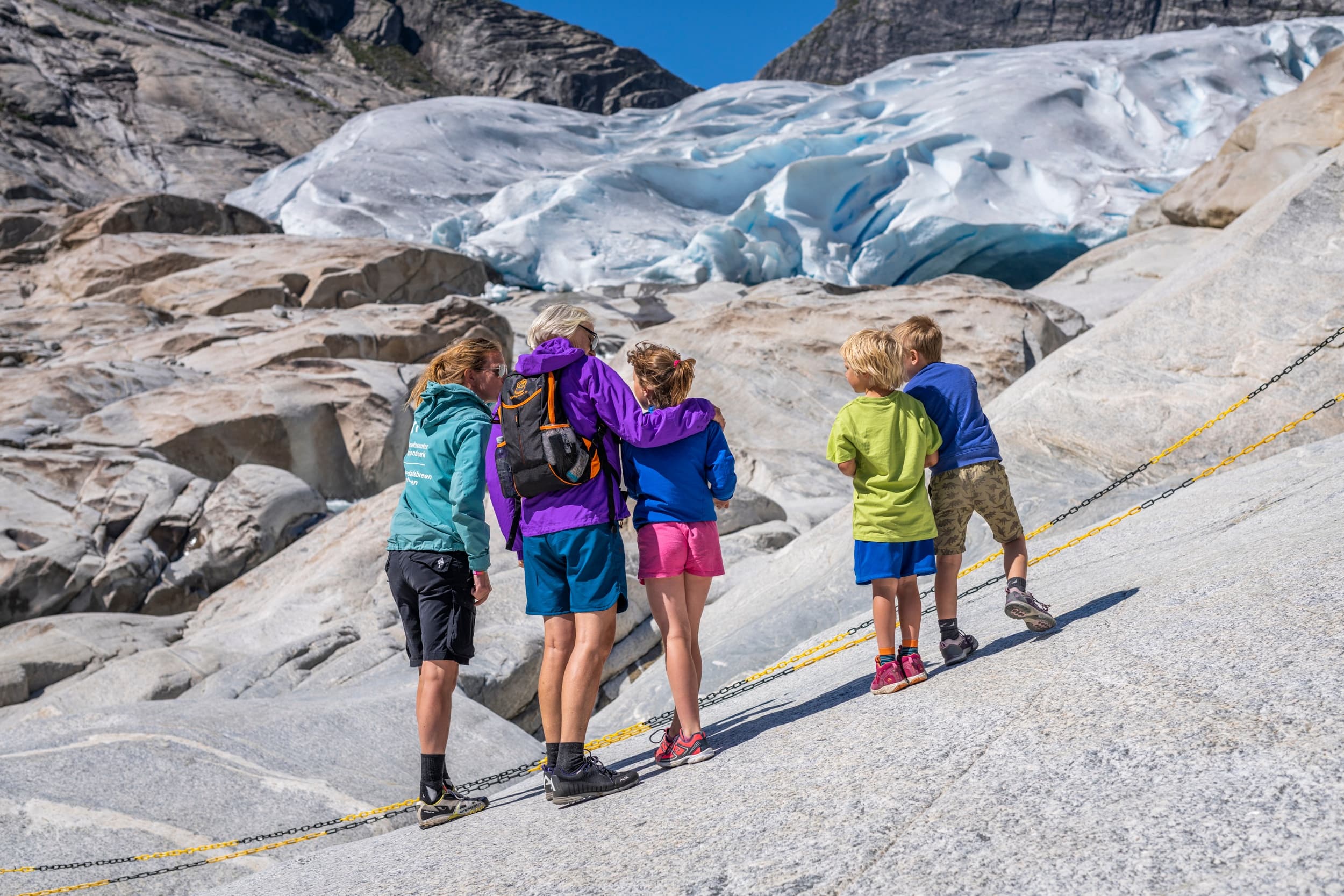 Hikers walking across rocky glacier terrain on guided trek