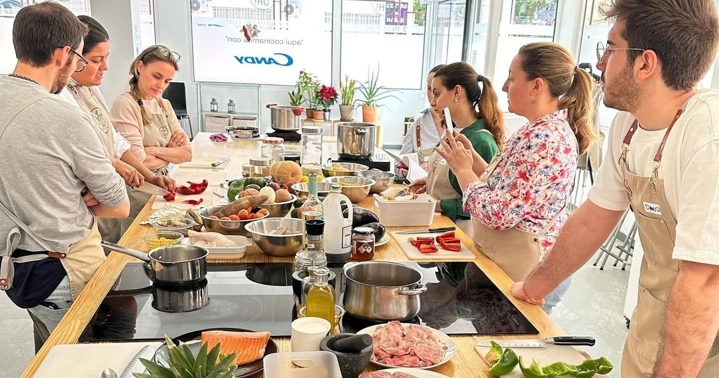 Group cooking class demo in bright communal kitchen studio