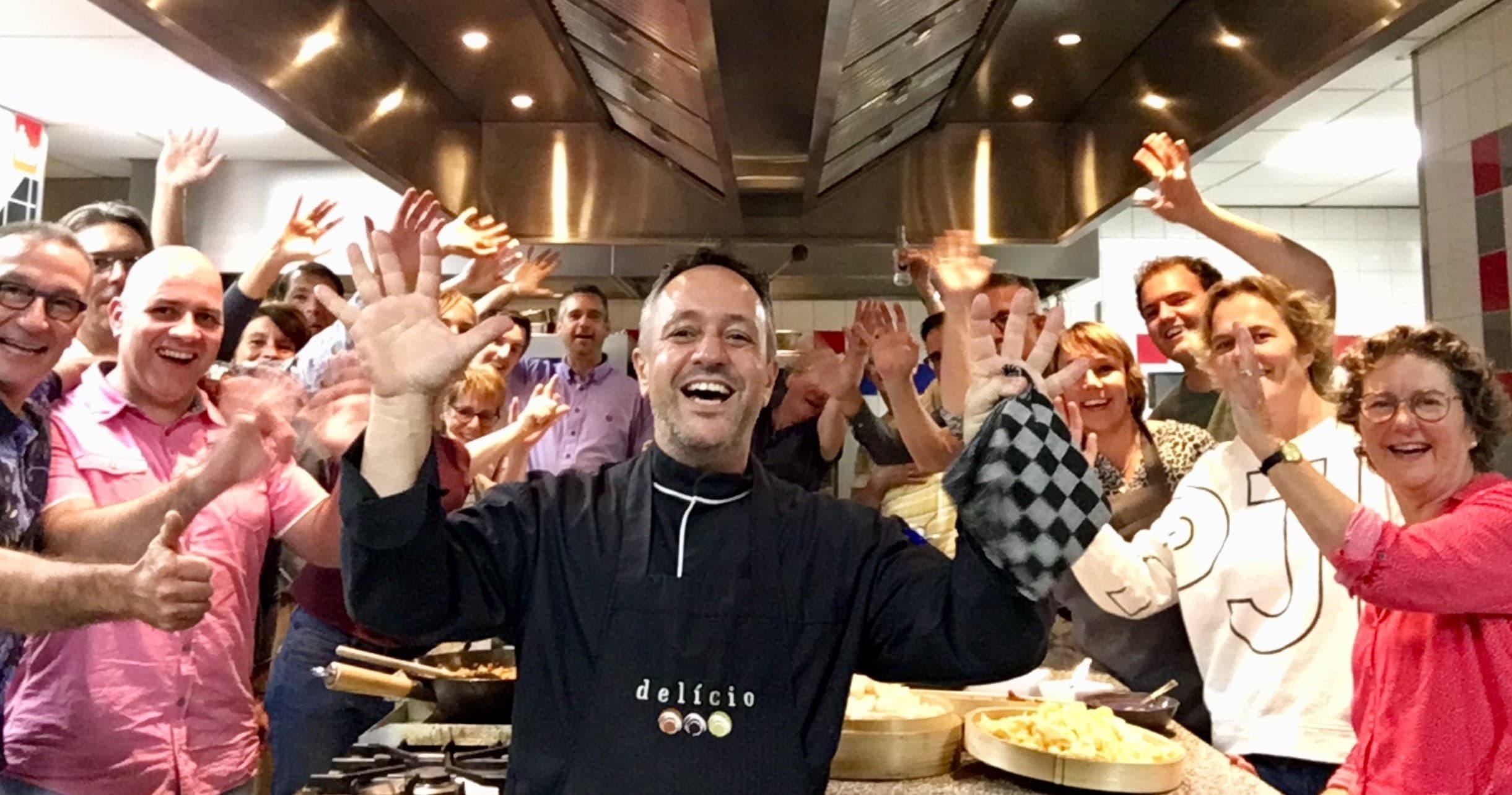 Chef leading lively cooking class in indoor commercial kitchen