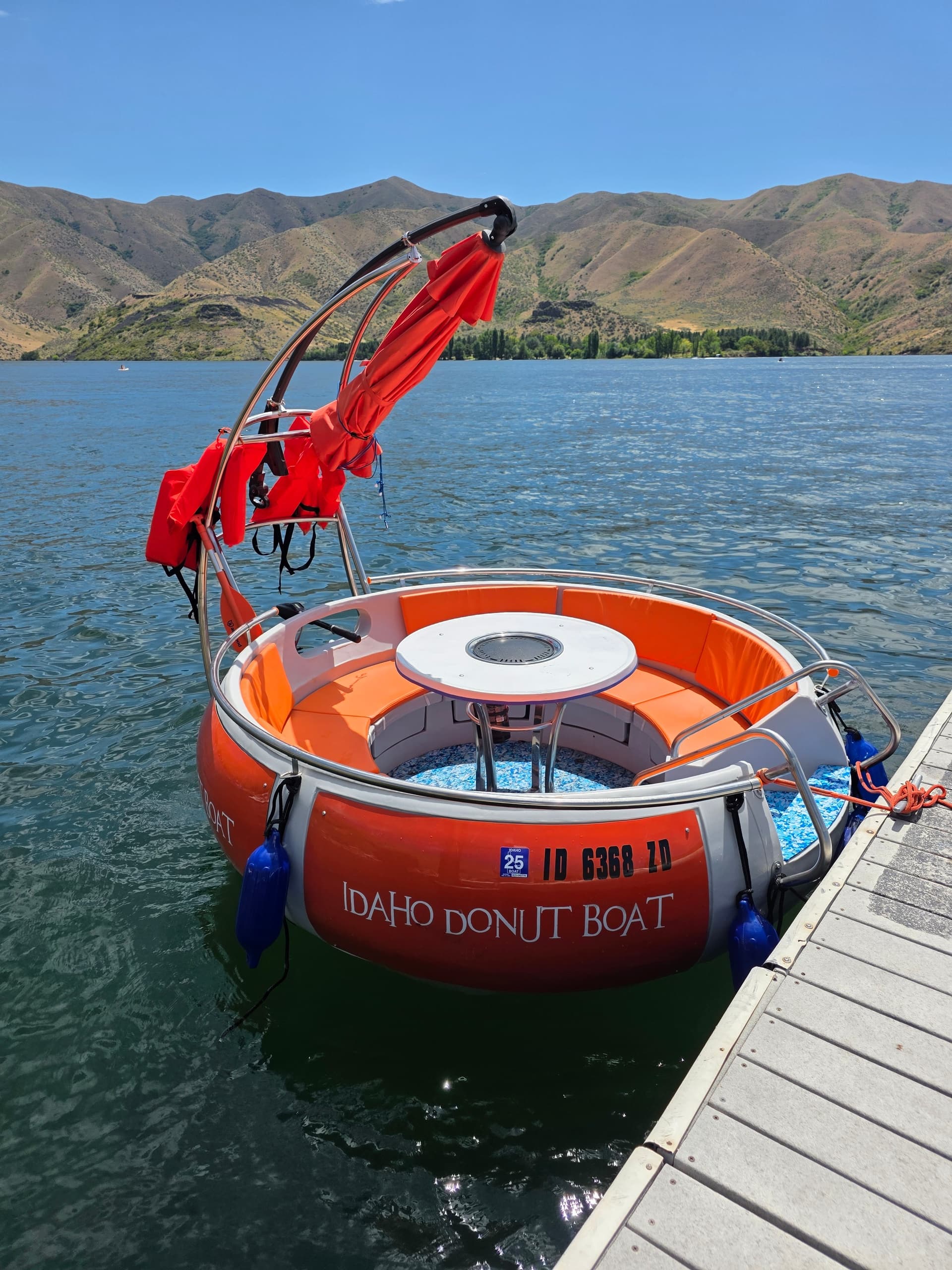 Orange donut boat moored at Idaho lake dock for group cruises
