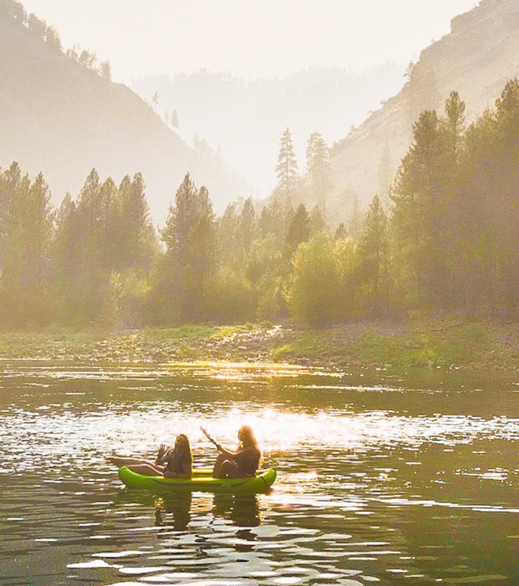 Sunset canoeing on golden river valley near Provo mountains