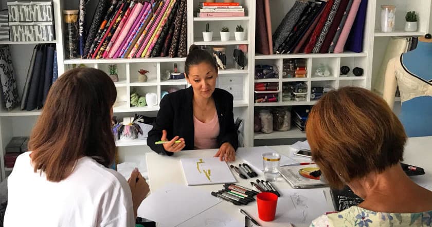 Designers collaborating at a bright sewing studio table