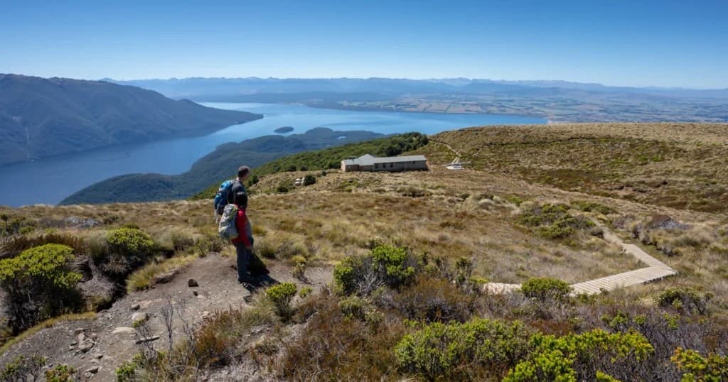 Hiker overlooking coastal lake from ridge in Southern Alps