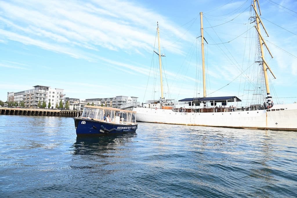 Historic tall ship sailing in Boston Harbor under blue sky
