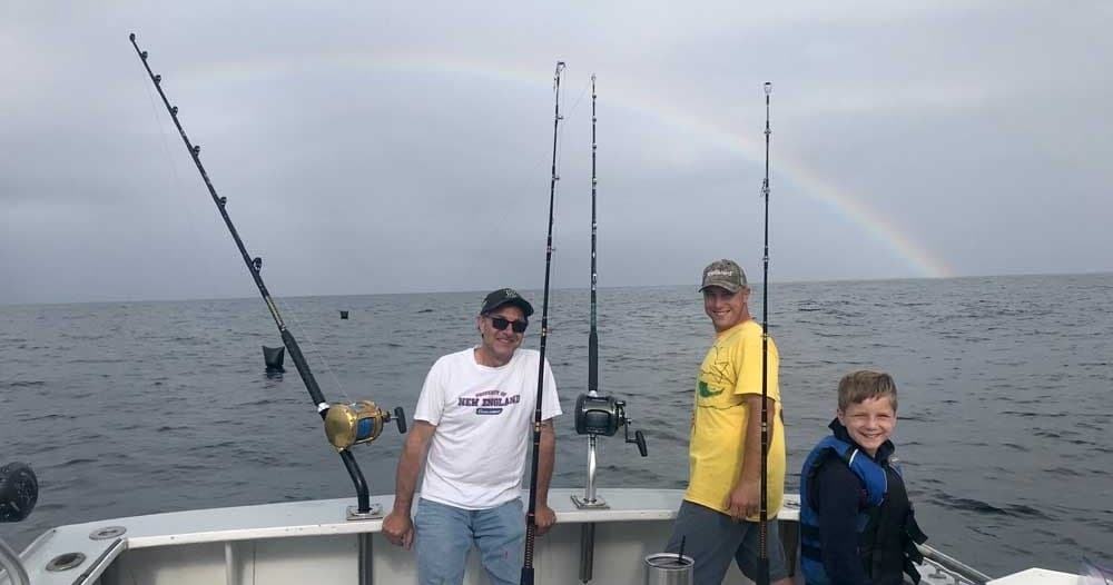 Offshore anglers on boat with rainbow during deep-sea fishing